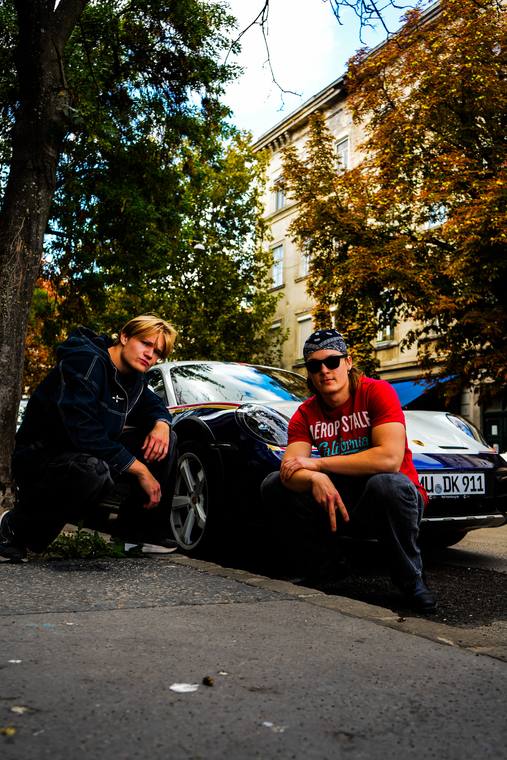 To venner på en bilmotorhjelm i gaden